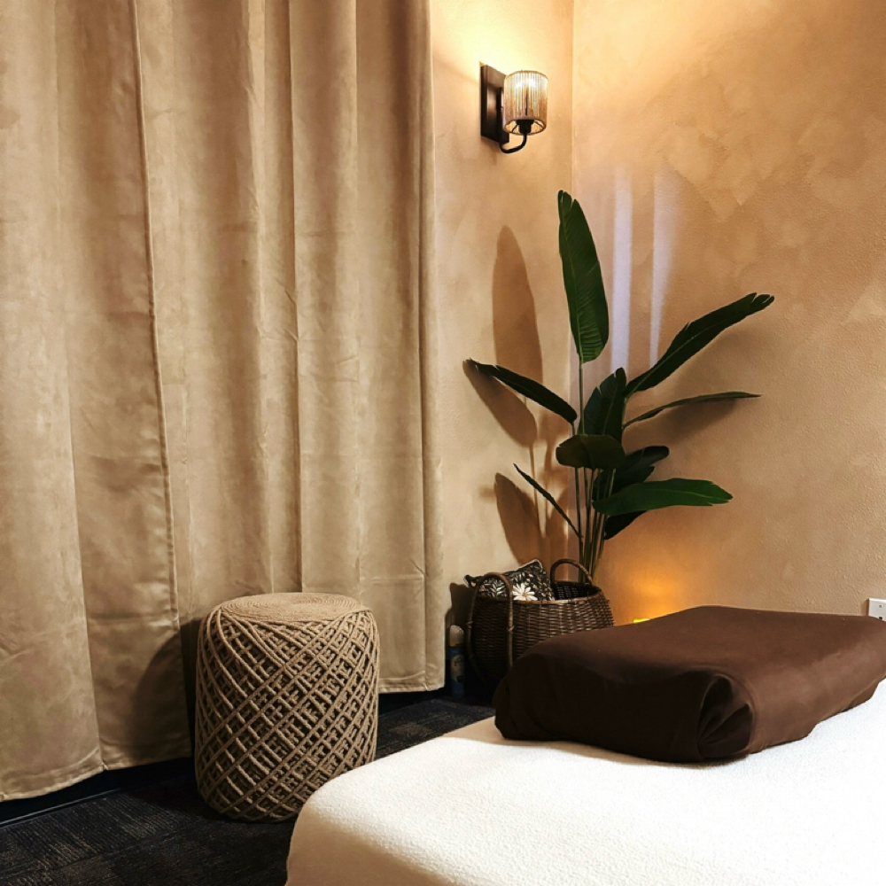 Massage treatment room with plant and warm lighting